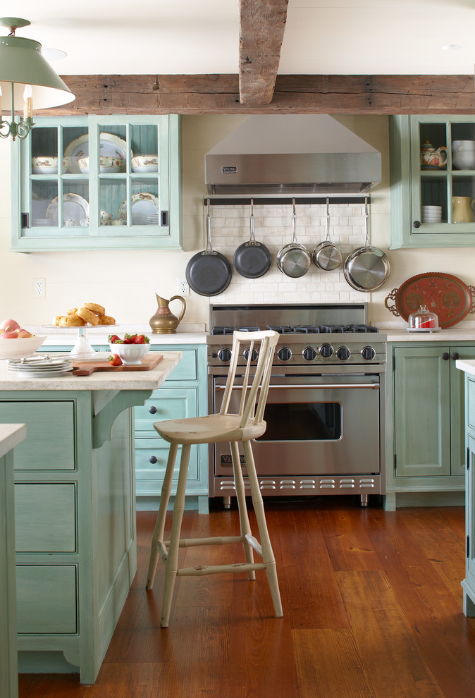 Inspiration for a mid-sized country u-shaped medium tone wood floor eat-in kitchen remodel in New York with beaded inset cabinets, granite countertops, white backsplash, ceramic backsplash, stainless steel appliances, an island and green cabinets