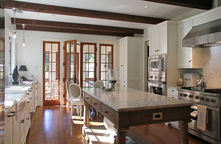 Exempel på ett stort klassiskt kök, med en rustik diskho, skåp i shakerstil, vita skåp, rostfria vitvaror, mellanmörkt trägolv, en köksö och brunt golv