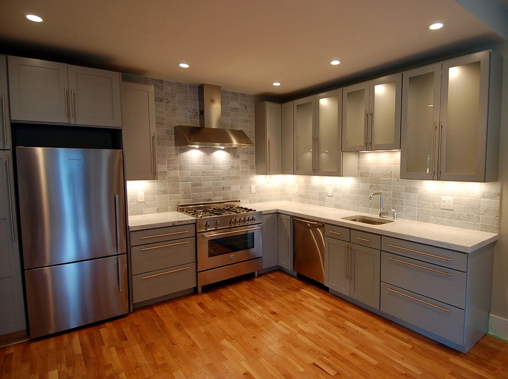 Moderne Küche in L-Form mit Schrankfronten mit vertiefter Füllung, grauen Schränken, Küchenrückwand in Grau und Küchengeräten aus Edelstahl in Boston