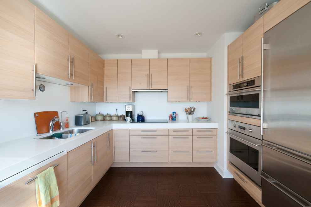 Foto di una cucina minimalista di medie dimensioni con lavello a doppia vasca, ante lisce, ante in legno chiaro, paraspruzzi bianco, elettrodomestici in acciaio inossidabile, parquet scuro e nessuna isola