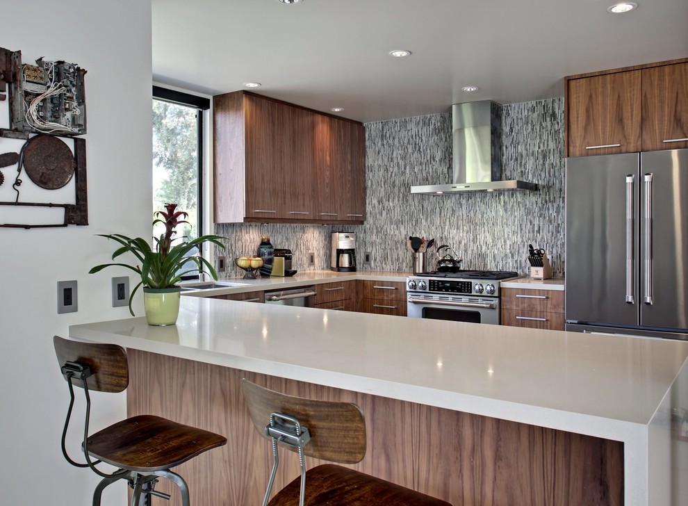Mid-sized trendy u-shaped eat-in kitchen photo in Los Angeles with a double-bowl sink, flat-panel cabinets, medium tone wood cabinets, multicolored backsplash, stainless steel appliances and a peninsula
