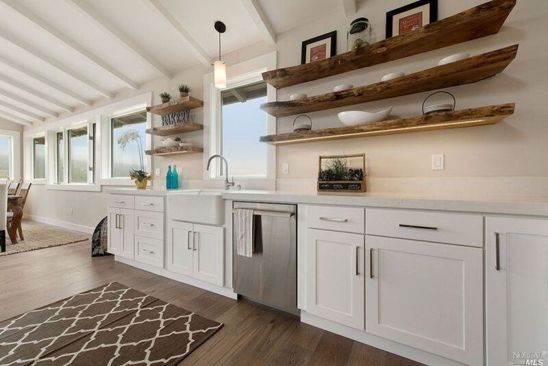 Inspiration for a mid-sized farmhouse single-wall medium tone wood floor and brown floor eat-in kitchen remodel in San Francisco with an island, a farmhouse sink, shaker cabinets, white cabinets, marble countertops, white backsplash, marble backsplash and stainless steel appliances