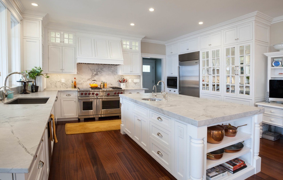 Klassische Küche in U-Form mit Schrankfronten mit vertiefter Füllung, weißen Schränken, dunklem Holzboden, Kücheninsel und Rückwand aus Marmor in Portland Maine