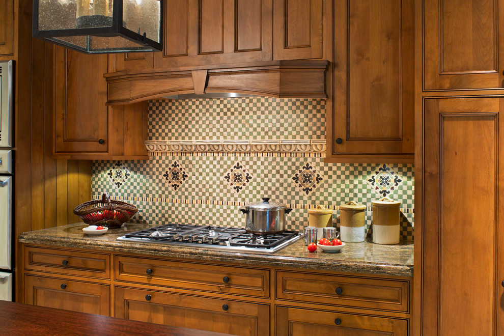 Exempel på ett stort rustikt linjärt kök, med granitbänkskiva, luckor med profilerade fronter, flerfärgad stänkskydd, stänkskydd i mosaik, rostfria vitvaror, en köksö och skåp i mellenmörkt trä