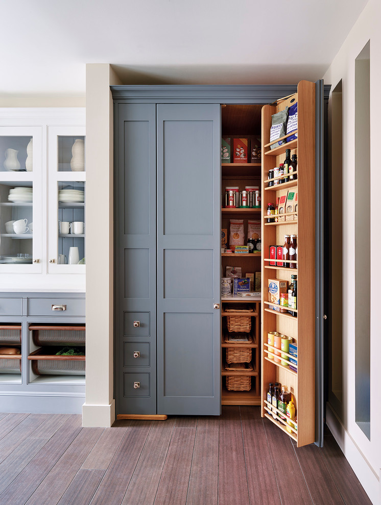 Cette image montre une arrière-cuisine bicolore traditionnelle avec un placard à porte shaker, des portes de placard grises et un sol en bois brun.