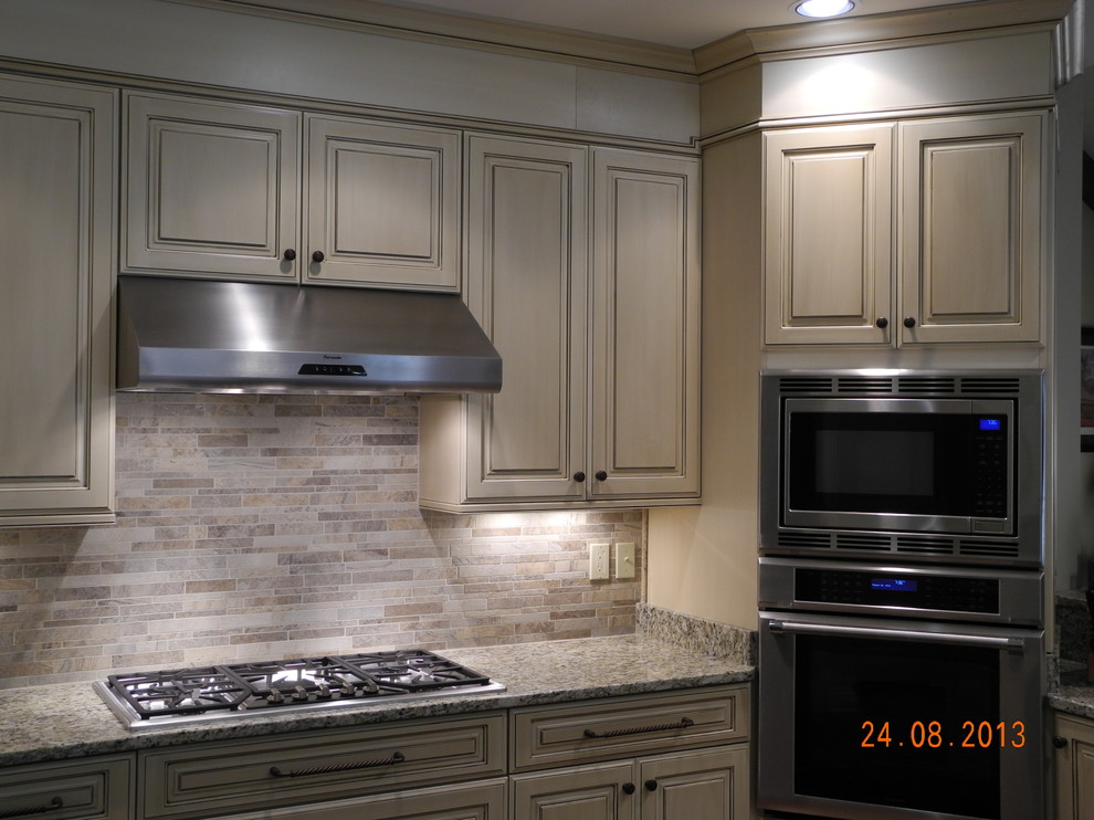 Foto di una cucina minimal di medie dimensioni con ante con bugna sagomata, ante beige, top in granito, paraspruzzi multicolore, paraspruzzi in gres porcellanato e elettrodomestici in acciaio inossidabile