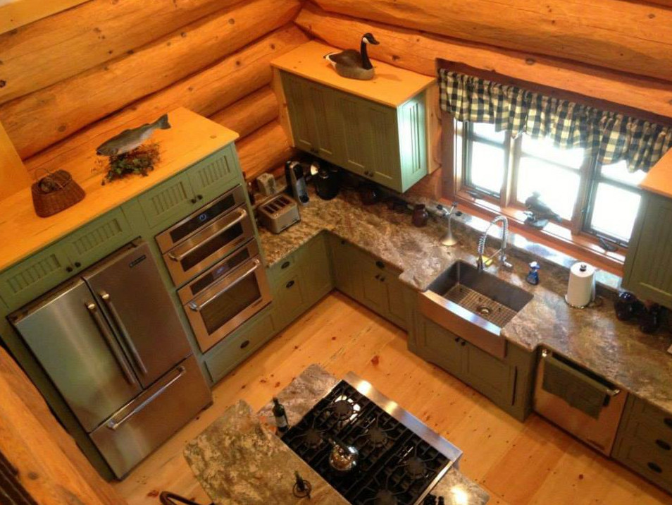 Inredning av ett rustikt mellanstort kök, med en dubbel diskho, luckor med upphöjd panel, gröna skåp, granitbänkskiva, beige stänkskydd, stänkskydd i stenkakel, rostfria vitvaror, mellanmörkt trägolv, en köksö och beiget golv