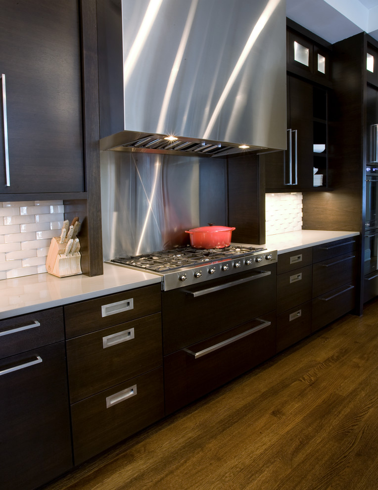 Inspiration for a large modern single-wall open plan kitchen in Chicago with flat-panel cabinets, dark wood cabinets, engineered stone countertops, white splashback, stainless steel appliances, dark hardwood flooring, no island and brown floors.