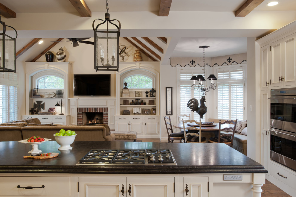 Klassisk inredning av ett kök med öppen planlösning, med luckor med infälld panel och vita skåp
