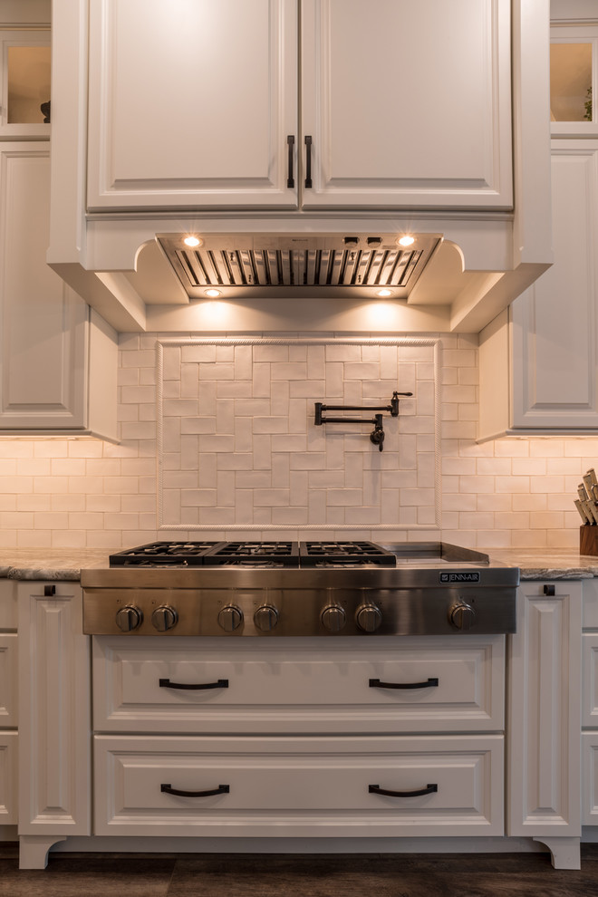 Idéer för att renovera ett stort lantligt grå grått kök, med luckor med upphöjd panel, vita skåp, vitt stänkskydd, stänkskydd i mosaik, rostfria vitvaror, laminatgolv, en köksö, brunt golv och granitbänkskiva
