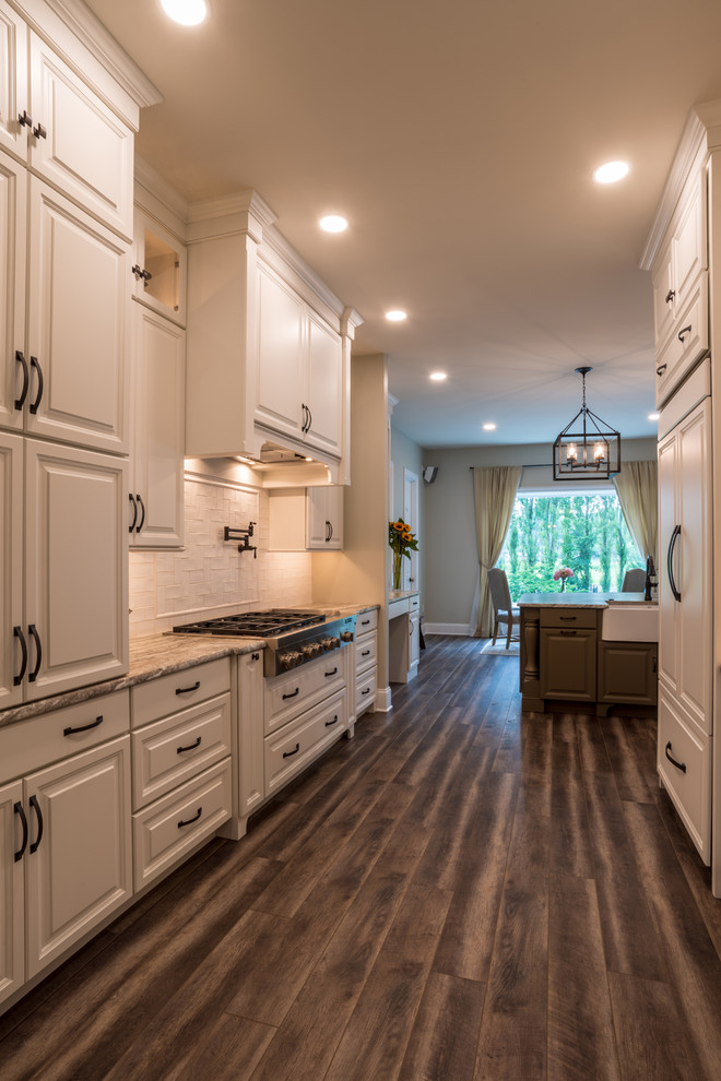 Exempel på ett stort lantligt grå grått kök och matrum, med en rustik diskho, luckor med upphöjd panel, vita skåp, vitt stänkskydd, stänkskydd i mosaik, rostfria vitvaror, laminatgolv, en köksö, brunt golv och granitbänkskiva