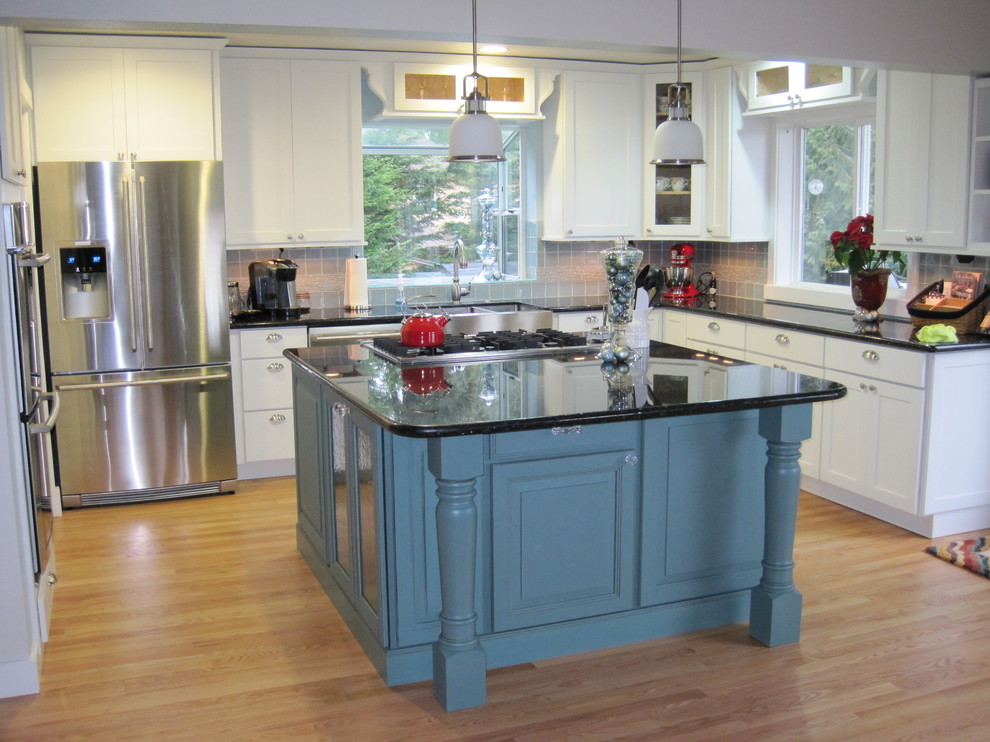 Example of a mid-sized classic u-shaped light wood floor and brown floor eat-in kitchen design in Seattle with a farmhouse sink, shaker cabinets, white cabinets, quartz countertops, gray backsplash, porcelain backsplash, stainless steel appliances and an island