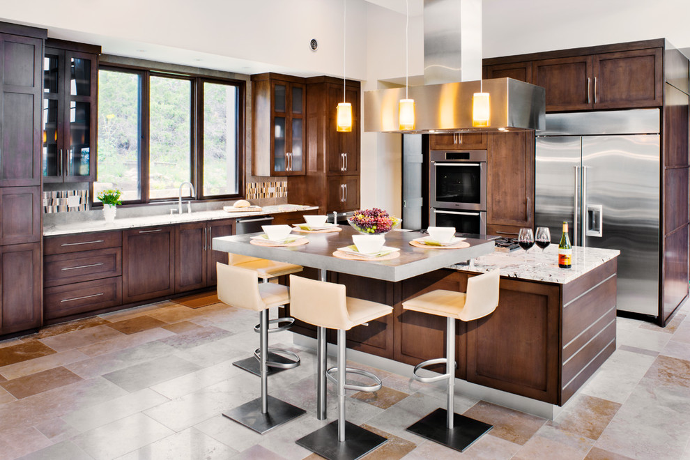 Large trendy l-shaped ceramic tile and multicolored floor eat-in kitchen photo in Austin with an island, a drop-in sink, recessed-panel cabinets, dark wood cabinets, laminate countertops, brown backsplash, ceramic backsplash and stainless steel appliances