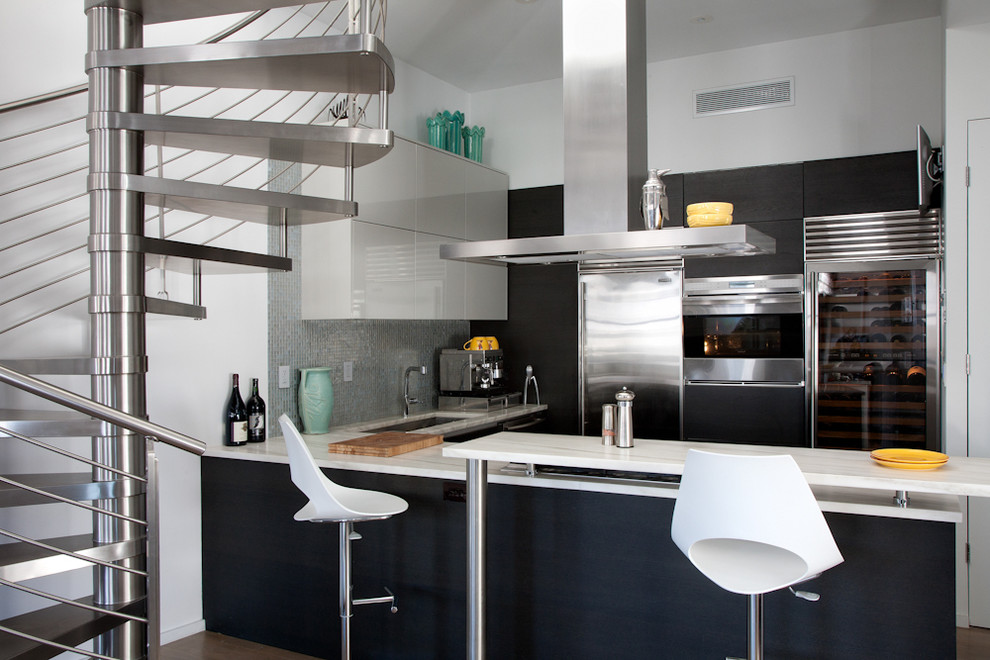 Kitchen - industrial kitchen idea in New York with stainless steel appliances, flat-panel cabinets and black cabinets