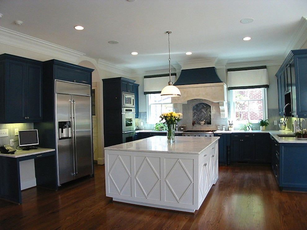 Esempio di una grande cucina con lavello sottopiano, ante con riquadro incassato, ante blu, top in pietra calcarea, elettrodomestici in acciaio inossidabile e parquet scuro