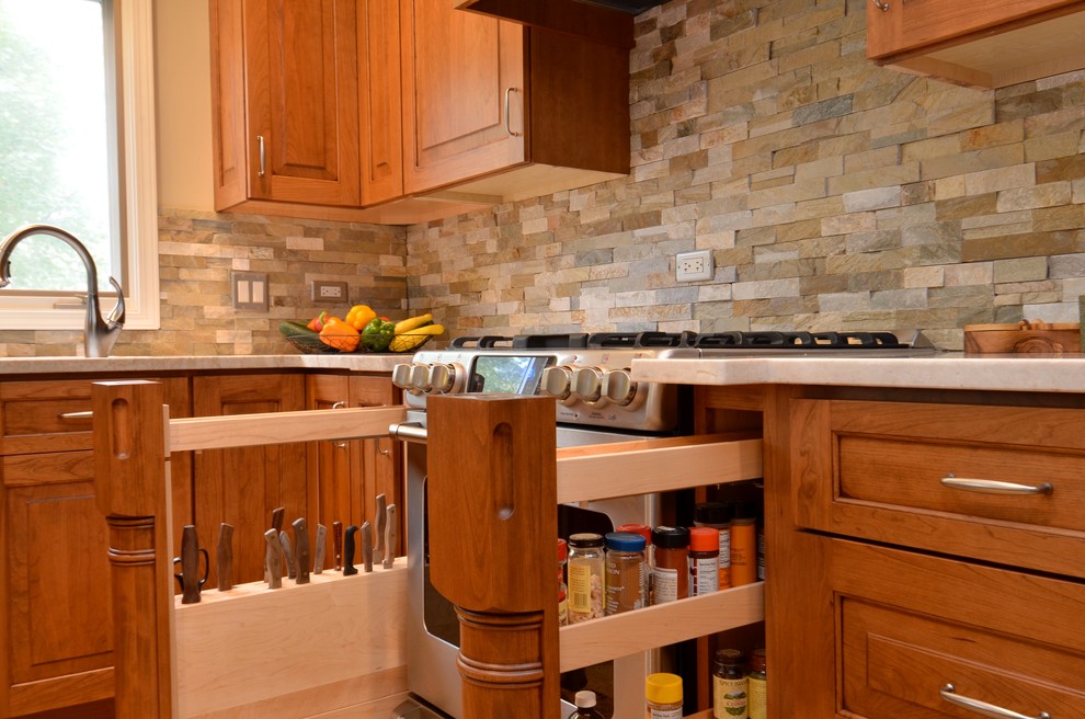 Klassisk inredning av ett mellanstort kök, med en undermonterad diskho, luckor med upphöjd panel, skåp i mellenmörkt trä, bänkskiva i kvartsit, flerfärgad stänkskydd, stänkskydd i stenkakel, rostfria vitvaror, klinkergolv i keramik och en halv köksö