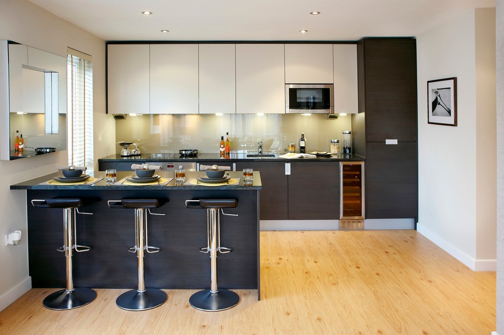 Moderne Küche mit Glasrückwand und Halbinsel in Essex