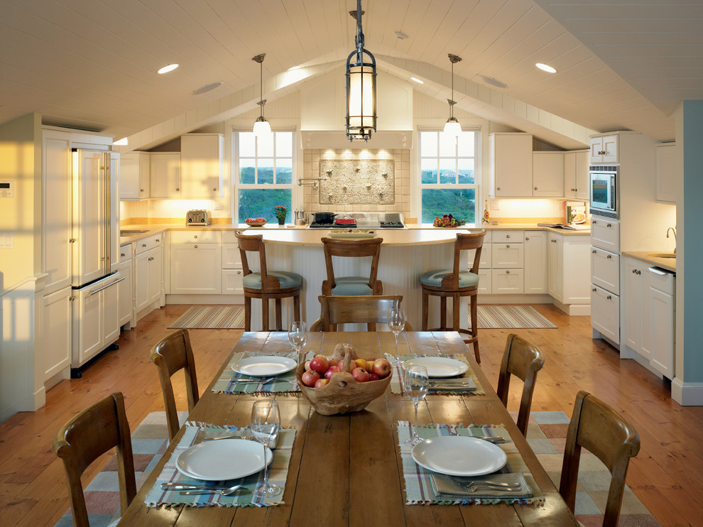 Пример оригинального дизайна: п-образная кухня в классическом стиле с обеденным столом, фасадами с утопленной филенкой и белыми фасадами