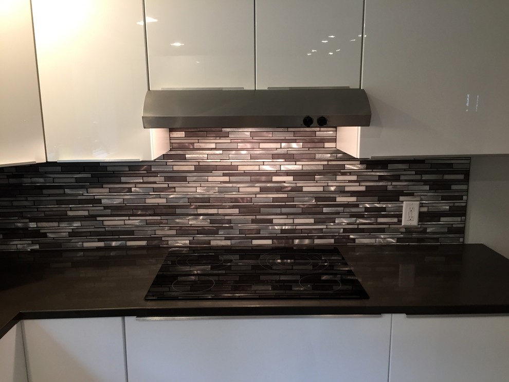 Contemporary kitchen in Portland Maine with flat-panel cabinets, white cabinets, engineered stone countertops, multi-coloured splashback and matchstick tiled splashback.
