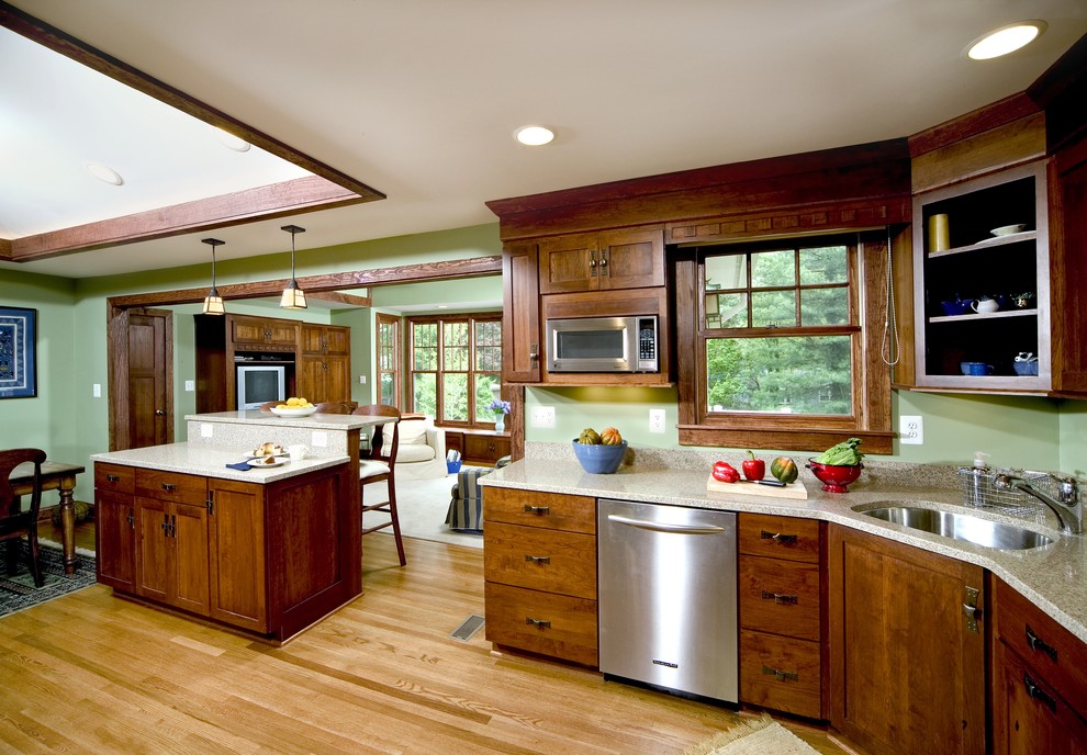 Exempel på ett avskilt, stort klassiskt l-kök, med en undermonterad diskho, skåp i mörkt trä, rostfria vitvaror, skåp i shakerstil, granitbänkskiva, mellanmörkt trägolv, en köksö och brunt golv