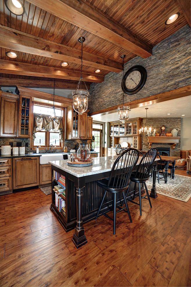 Foto di una cucina rustica con lavello stile country, ante con bugna sagomata, ante in legno scuro e pavimento in legno massello medio