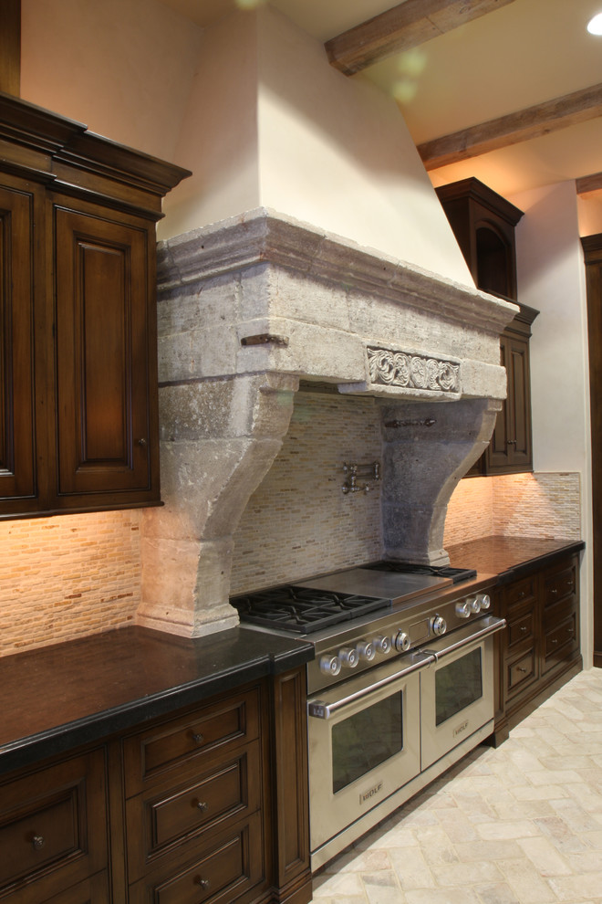 Exempel på ett stort medelhavsstil kök, med en rustik diskho, öppna hyllor, skåp i mörkt trä, bänkskiva i kalksten, beige stänkskydd, stänkskydd i stenkakel, rostfria vitvaror, kalkstensgolv och en köksö