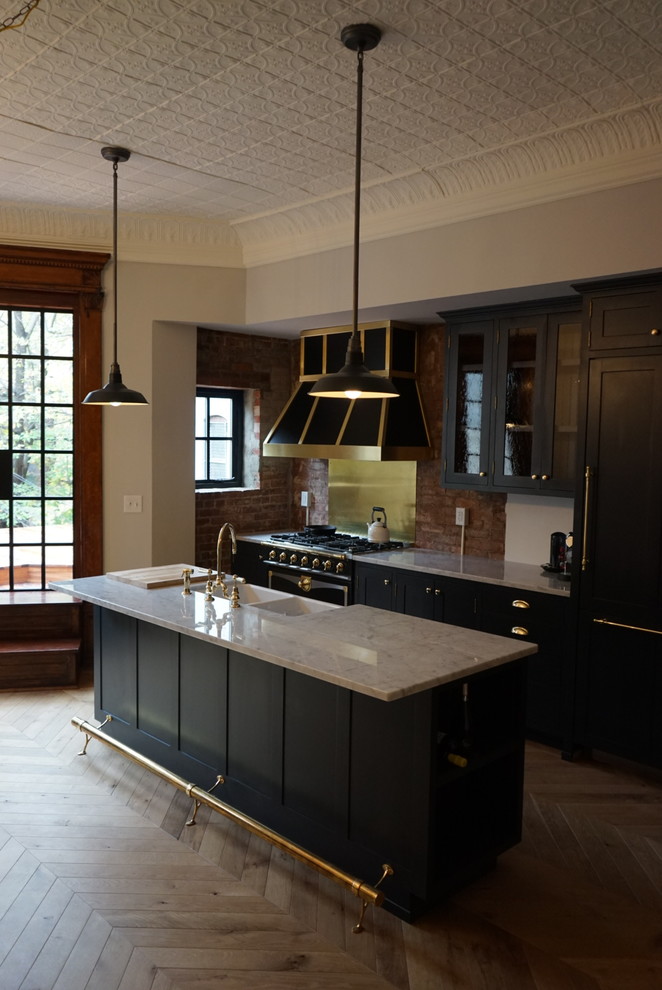 Mid-sized transitional galley painted wood floor open concept kitchen photo in New York with a farmhouse sink, shaker cabinets, black cabinets, marble countertops, red backsplash, stone tile backsplash, colored appliances and an island