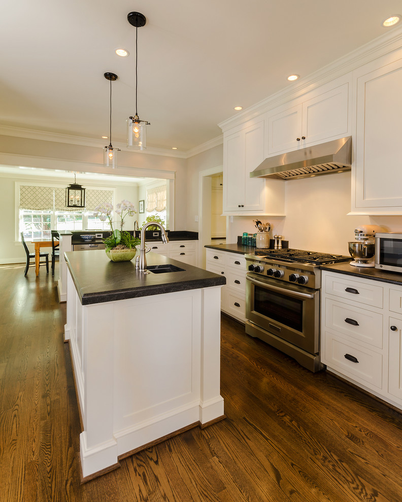This is an example of a classic u-shaped kitchen/diner in Richmond with shaker cabinets, white cabinets, stainless steel appliances, dark hardwood flooring and an island.