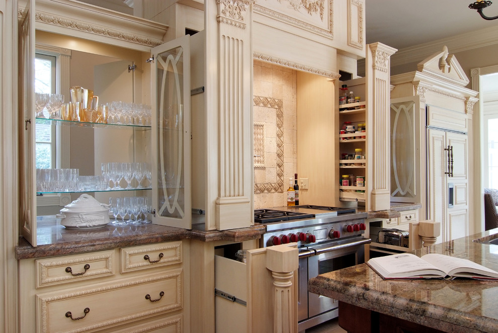 Medelhavsstil inredning av ett kök, med luckor med infälld panel, beige skåp, granitbänkskiva, beige stänkskydd och rostfria vitvaror
