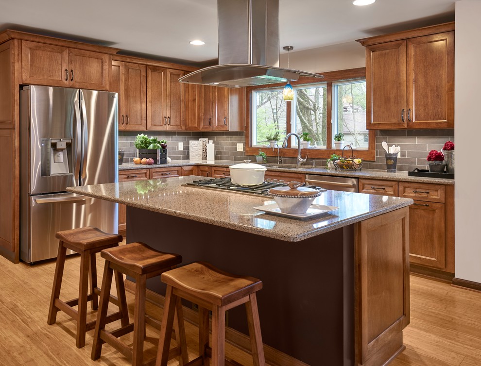 Idéer för att renovera ett stort vintage brun brunt l-kök, med en undermonterad diskho, luckor med infälld panel, skåp i mellenmörkt trä, granitbänkskiva, grått stänkskydd, rostfria vitvaror, mellanmörkt trägolv, en köksö och brunt golv