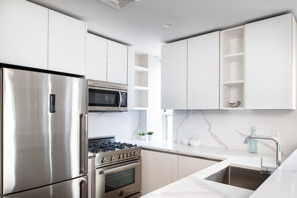 Modern inredning av ett litet vit vitt u-kök, med luckor med glaspanel, vita skåp, bänkskiva i glas, vitt stänkskydd och en halv köksö