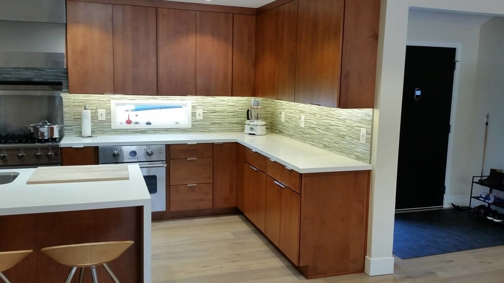 Eat-in kitchen - large contemporary u-shaped light wood floor eat-in kitchen idea in San Francisco with an undermount sink, flat-panel cabinets, medium tone wood cabinets, quartz countertops, green backsplash, glass tile backsplash, stainless steel appliances and an island