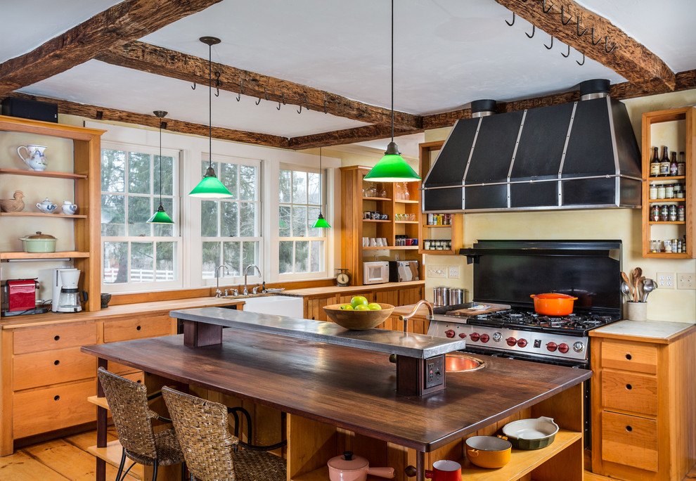 ブリッジポートにあるカントリー風のおしゃれなアイランドキッチン (エプロンフロントシンク、オープンシェルフ、中間色木目調キャビネット、木材カウンター、黒い調理設備) の写真