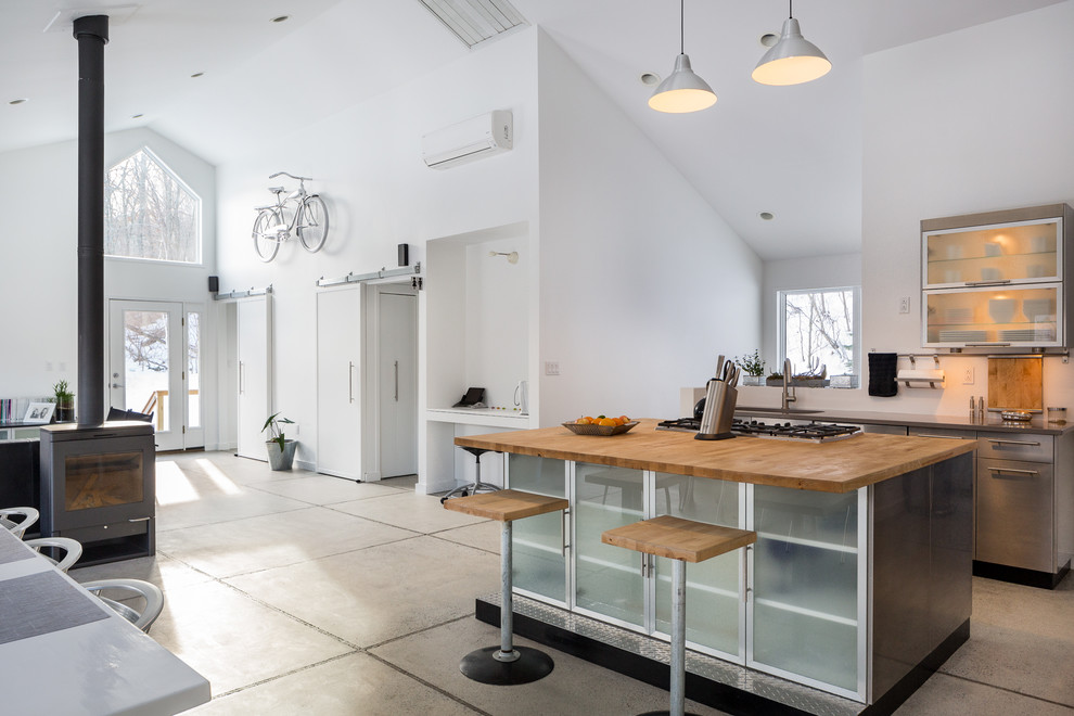 Offene Moderne Küche mit Glasfronten, Edelstahlfronten, Arbeitsplatte aus Holz, Betonboden und Kücheninsel in Bridgeport