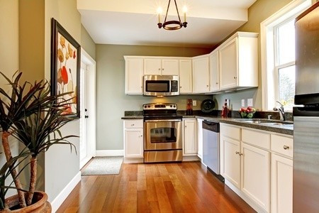 Bild på ett mellanstort rustikt linjärt kök och matrum, med en dubbel diskho, luckor med infälld panel, vita skåp, granitbänkskiva, vitt stänkskydd, stänkskydd i stenkakel, rostfria vitvaror och mellanmörkt trägolv