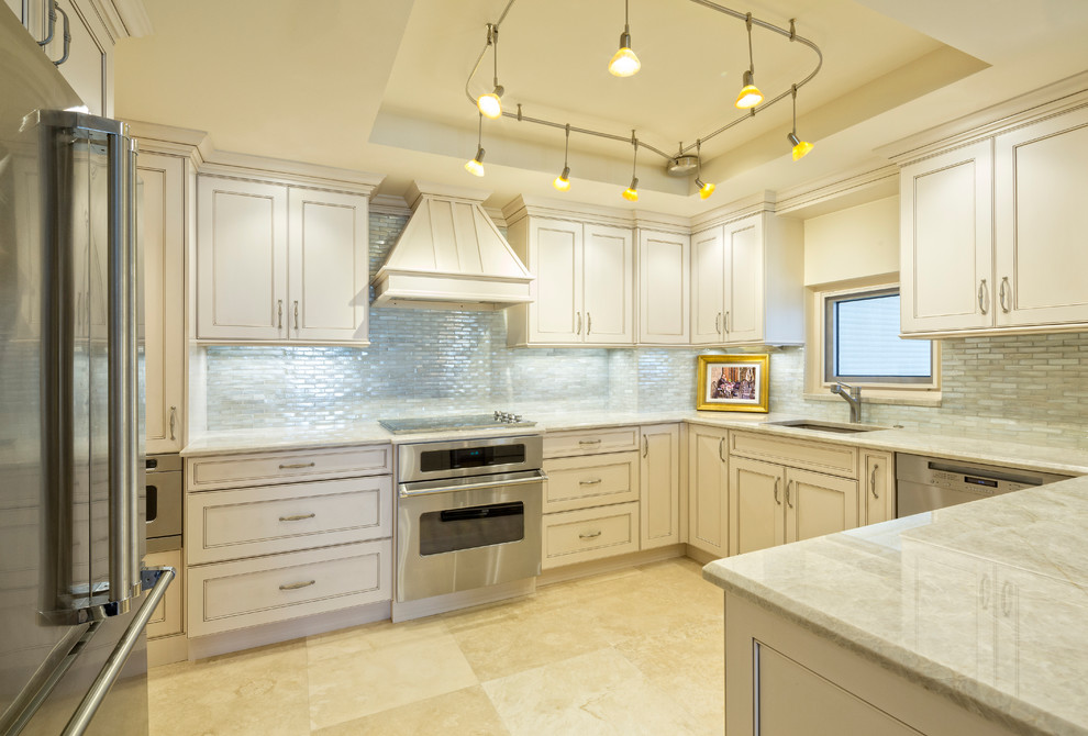 Medium sized traditional u-shaped kitchen in Austin with a submerged sink, beaded cabinets, beige cabinets, grey splashback, matchstick tiled splashback, stainless steel appliances, porcelain flooring, a breakfast bar and beige floors.