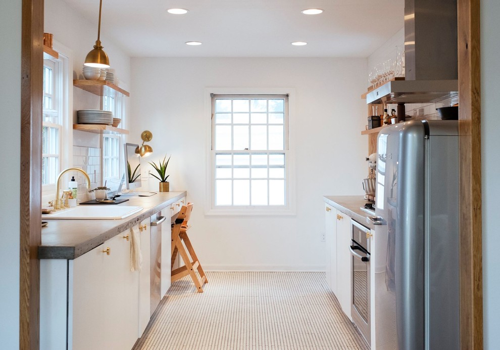 Zweizeilige Country Küche in grau-weiß ohne Insel mit Einbauwaschbecken, weißen Schränken, Betonarbeitsplatte, Küchenrückwand in Weiß und Rückwand aus Metrofliesen in Portland
