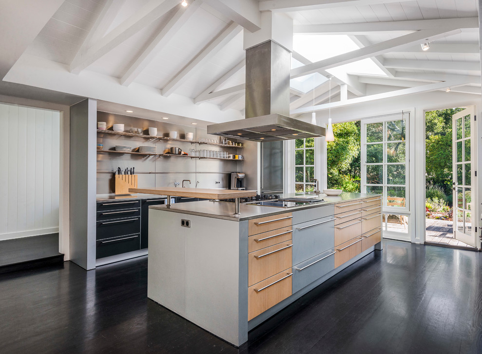 Zweizeilige Moderne Küche mit flächenbündigen Schrankfronten, schwarzen Schränken, Küchengeräten aus Edelstahl, dunklem Holzboden und Kücheninsel in Santa Barbara
