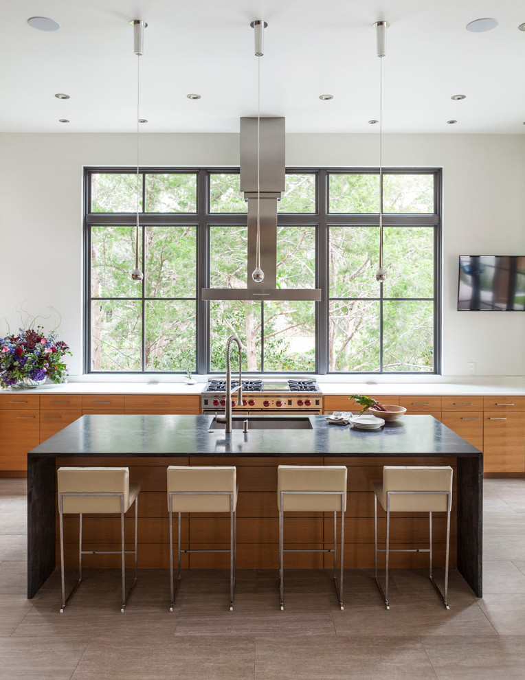 Inspiration for a contemporary galley kitchen in Dallas with a submerged sink, flat-panel cabinets, medium wood cabinets, stainless steel appliances and an island.