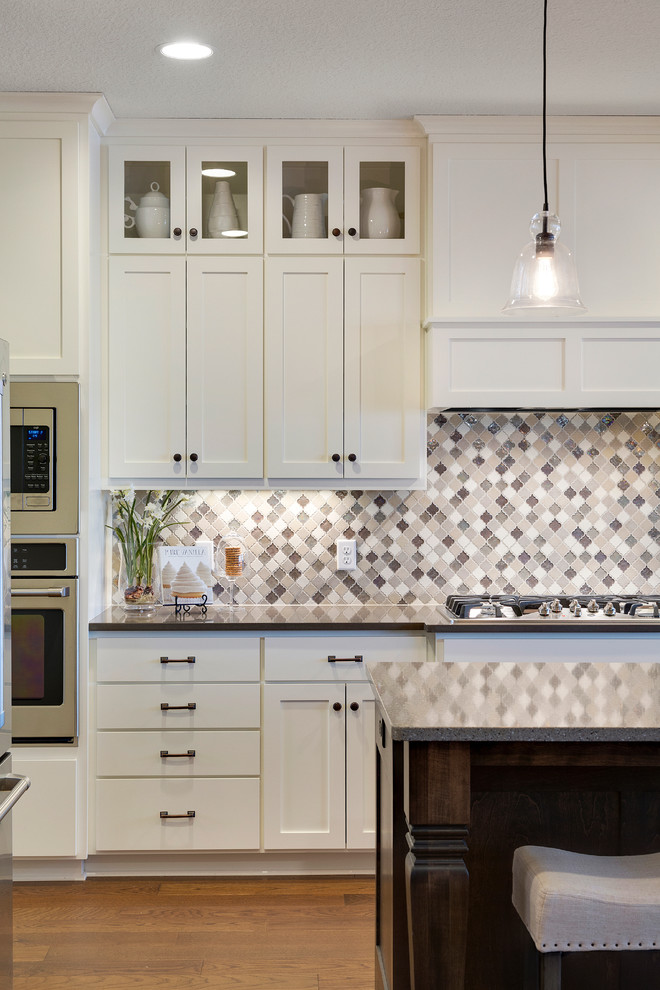 Foto på ett funkis kök, med en dubbel diskho, vita skåp, bänkskiva i kvartsit, vitt stänkskydd, stänkskydd i keramik, rostfria vitvaror, mörkt trägolv och en köksö