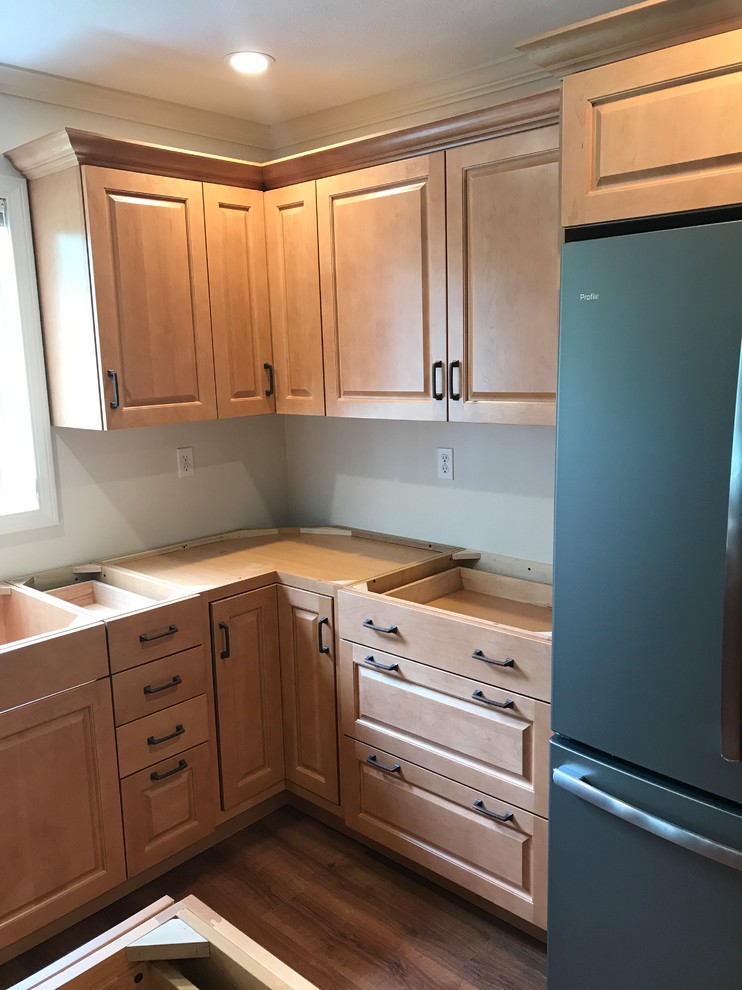 Inredning av ett klassiskt kök, med luckor med upphöjd panel, orange skåp, bänkskiva i kvartsit, vinylgolv, en köksö och brunt golv
