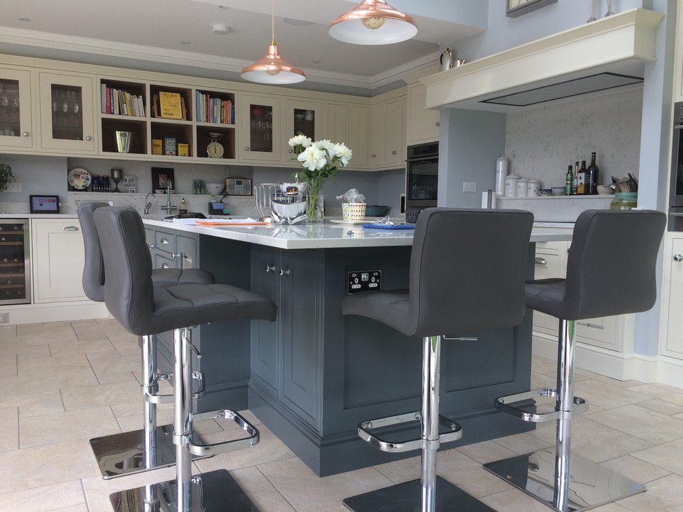 Photo of a large modern l-shaped kitchen/diner in Kent with a double-bowl sink, shaker cabinets, grey cabinets, quartz worktops, stainless steel appliances, porcelain flooring, an island and beige floors.