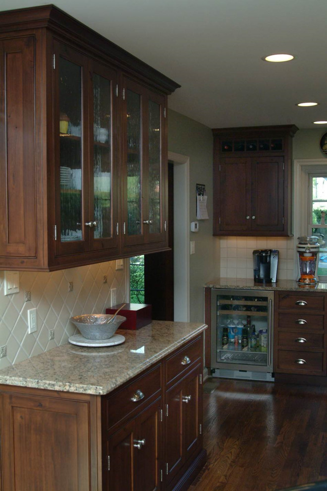 Modern inredning av ett stort kök, med en rustik diskho, luckor med infälld panel, skåp i mörkt trä, granitbänkskiva, vitt stänkskydd, stänkskydd i keramik, rostfria vitvaror, mellanmörkt trägolv och en köksö