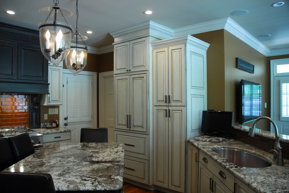 Medium sized classic l-shaped open plan kitchen in Atlanta with a submerged sink, raised-panel cabinets, white cabinets, red splashback, metro tiled splashback, stainless steel appliances, dark hardwood flooring, multiple islands and brown floors.
