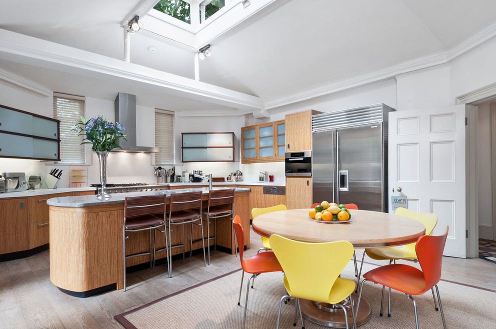Example of a large transitional light wood floor and beige floor eat-in kitchen design in Hampshire with stainless steel appliances and an island