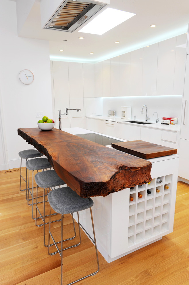 Kitchen - eclectic u-shaped kitchen idea in San Francisco with a double-bowl sink, flat-panel cabinets, white cabinets, wood countertops and white countertops