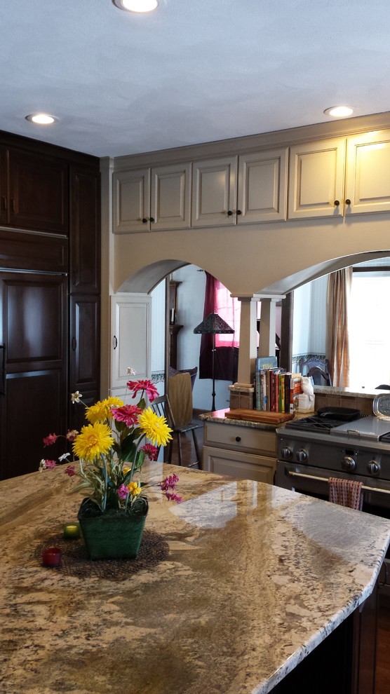 Foto på ett mellanstort, avskilt vintage l-kök, med en köksö, en undermonterad diskho, luckor med upphöjd panel, vita skåp, granitbänkskiva, beige stänkskydd, stänkskydd i keramik, rostfria vitvaror, ljust trägolv och brunt golv