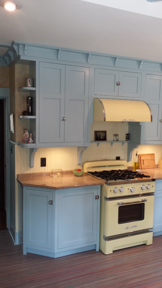 Exempel på ett mellanstort eklektiskt linjärt kök och matrum, med luckor med infälld panel, blå skåp, beige stänkskydd, färgglada vitvaror, granitbänkskiva, stänkskydd i trä, linoleumgolv och rött golv