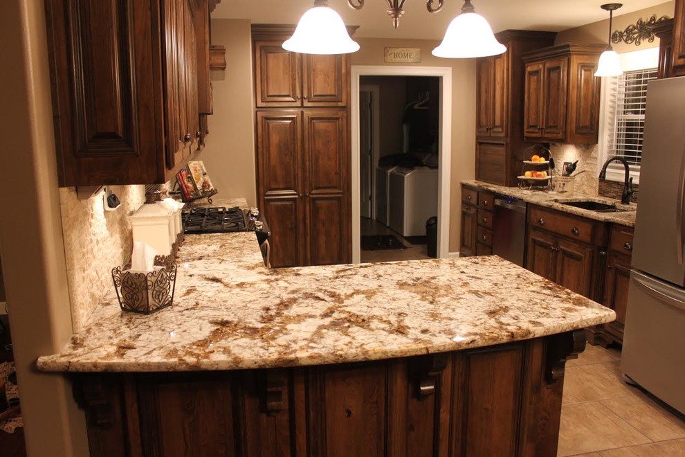 Foto di una cucina classica con lavello sottopiano, top in granito, paraspruzzi marrone, paraspruzzi con piastrelle di vetro, elettrodomestici in acciaio inossidabile e pavimento in gres porcellanato