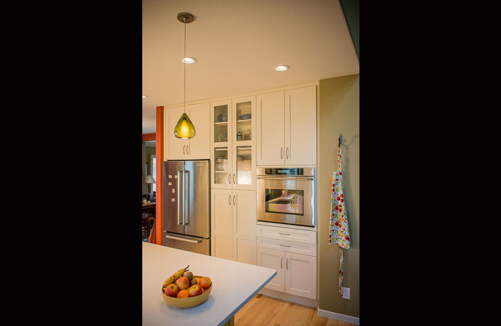 Example of a large trendy single-wall light wood floor eat-in kitchen design in Denver with shaker cabinets, white cabinets, quartz countertops, stainless steel appliances and an island